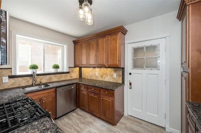 kitchen featuring sink, light hardwood / wood-style flooring, dark stone countertops, dishwasher, and decorative backsplash