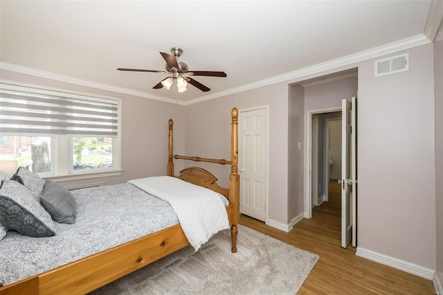 bedroom featuring hardwood / wood-style floors, ornamental molding, and ceiling fan