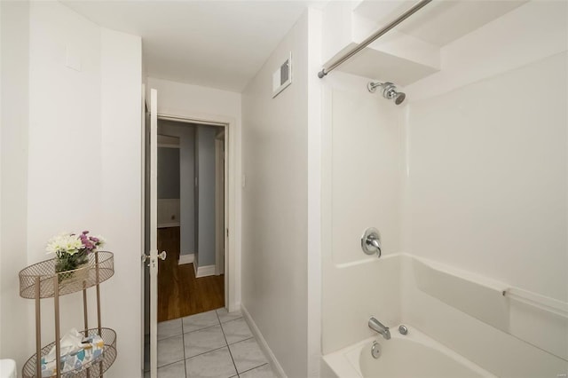 bathroom with tile patterned floors and shower / washtub combination