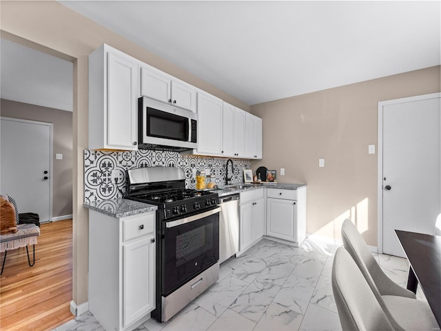 kitchen featuring white cabinetry, sink, tasteful backsplash, and appliances with stainless steel finishes