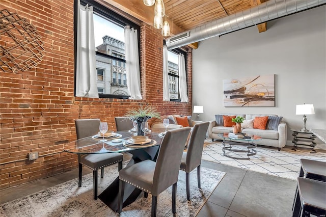 dining room featuring a high ceiling, brick wall, wooden ceiling, and concrete floors