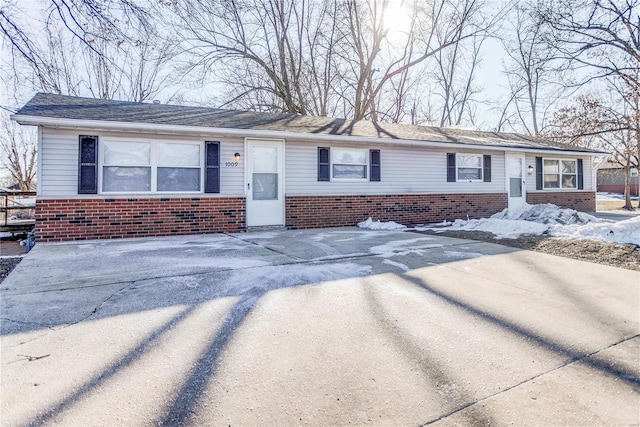 ranch-style home featuring brick siding and driveway