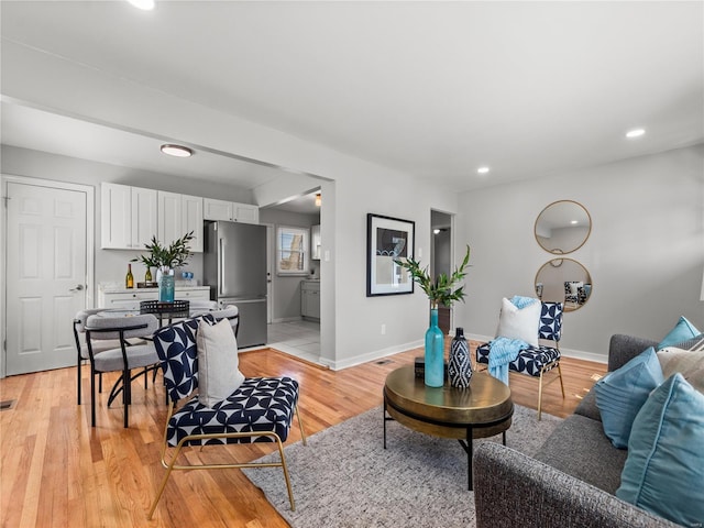 living area featuring light wood-style flooring, baseboards, and recessed lighting