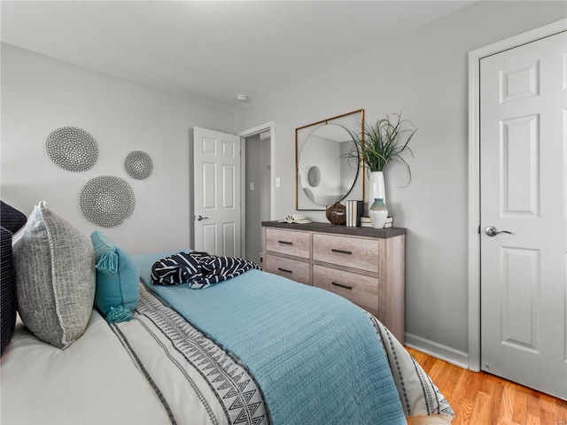 bedroom with light wood-type flooring and baseboards