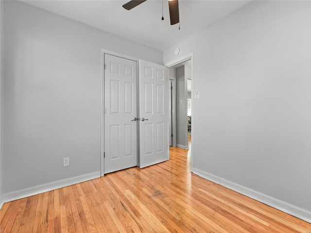 unfurnished bedroom featuring light wood-style floors, baseboards, and a ceiling fan