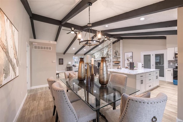 dining room featuring a fireplace, light hardwood / wood-style flooring, a notable chandelier, and vaulted ceiling with beams