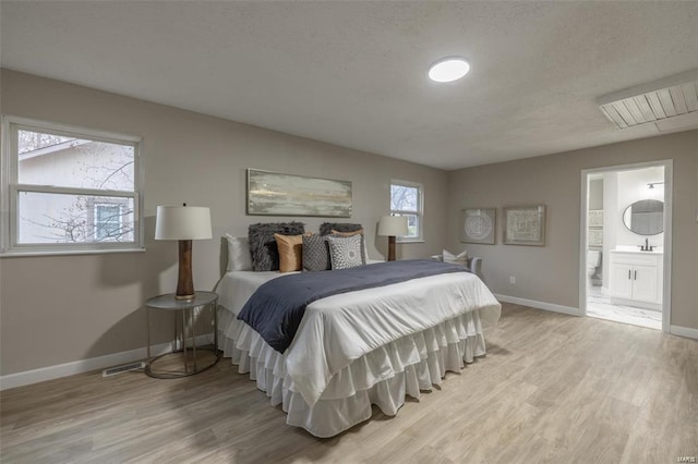 bedroom featuring light hardwood / wood-style floors and ensuite bath