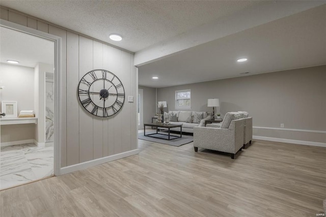 living room featuring a textured ceiling and light wood-type flooring