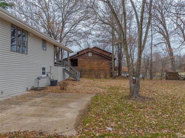 view of yard featuring central AC and a patio