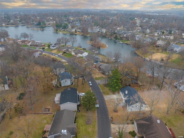 aerial view at dusk featuring a water view