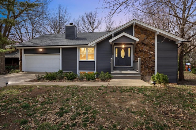 view of front of house with stone siding, a garage, driveway, and a chimney