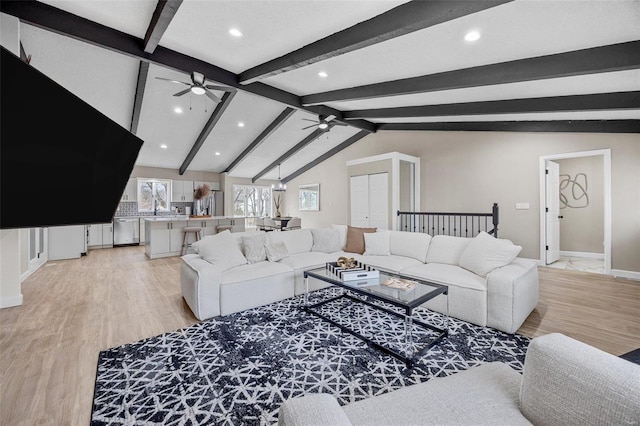 living area with a ceiling fan, lofted ceiling with beams, recessed lighting, light wood-style floors, and baseboards