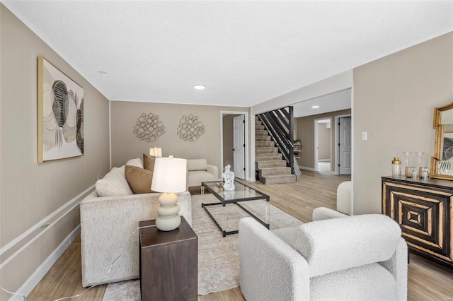 living area featuring stairway, recessed lighting, baseboards, and wood finished floors