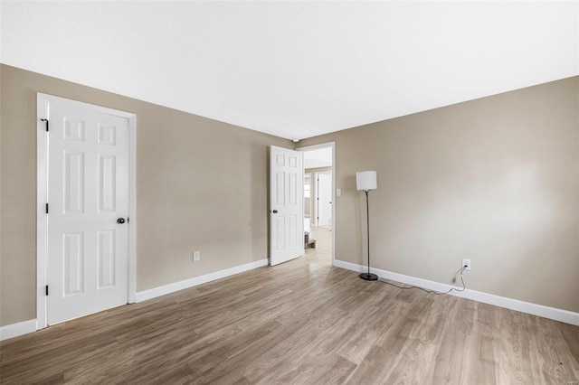 spare room featuring wood finished floors and baseboards