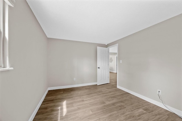 empty room with light wood-type flooring and baseboards