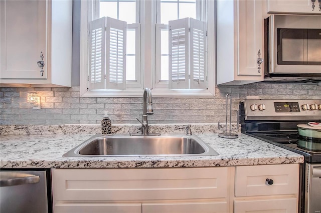 kitchen featuring sink, stainless steel appliances, and white cabinetry