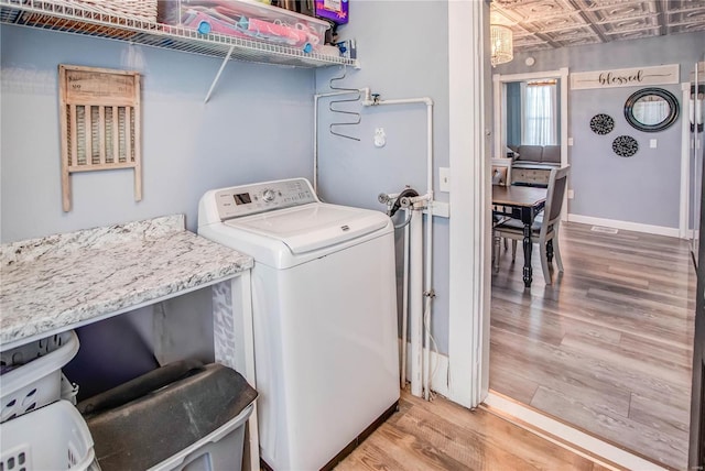 washroom featuring hardwood / wood-style flooring and washer / dryer