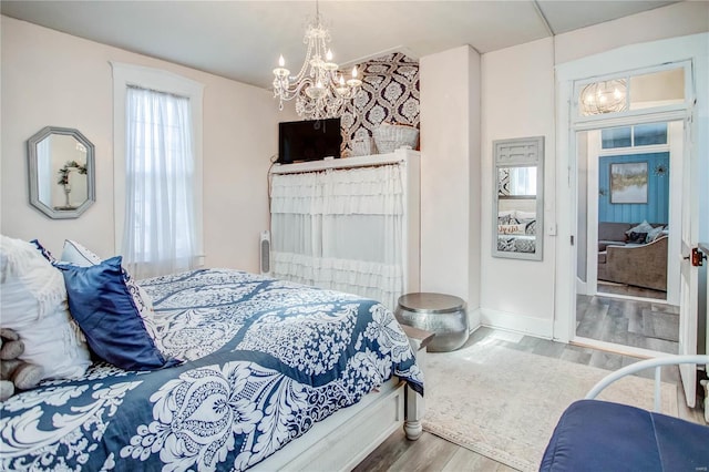 bedroom with a notable chandelier and hardwood / wood-style flooring