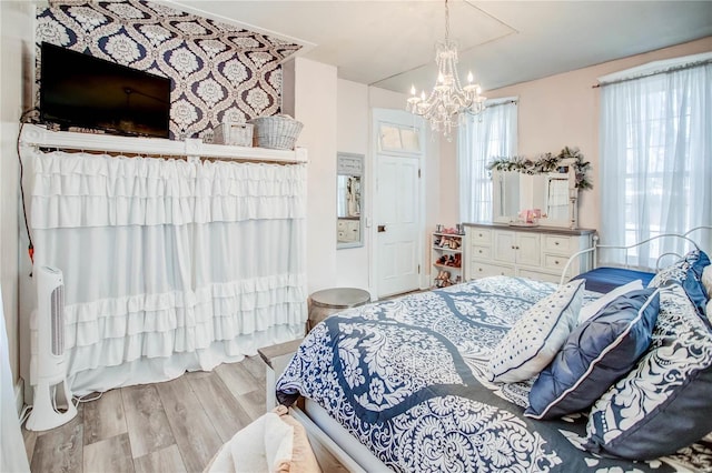 bedroom featuring light hardwood / wood-style flooring and a chandelier