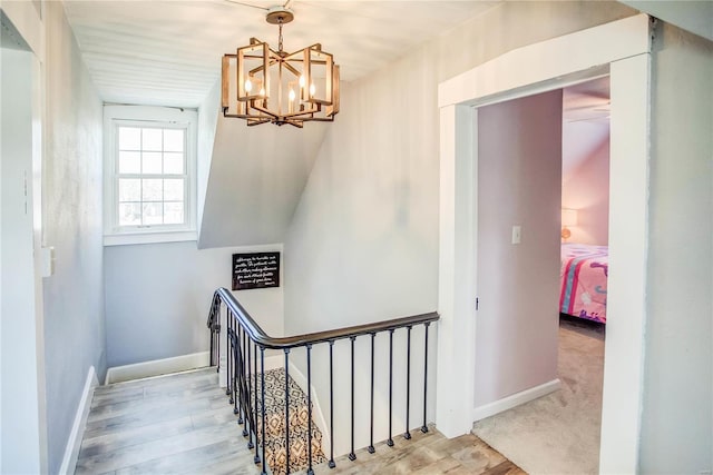 stairway featuring a notable chandelier and carpet flooring