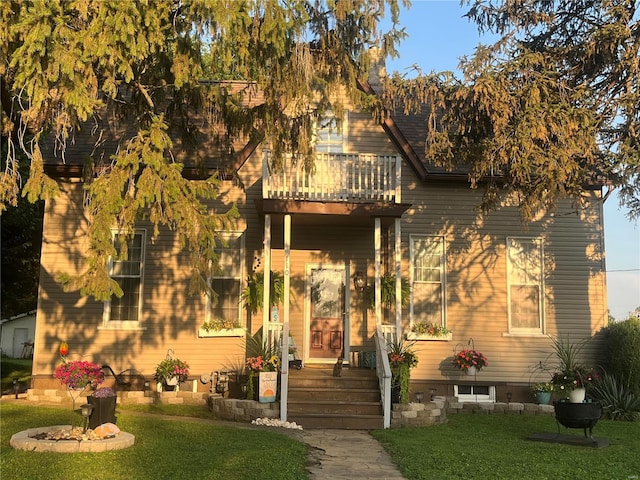 view of front of home featuring a front yard and a balcony