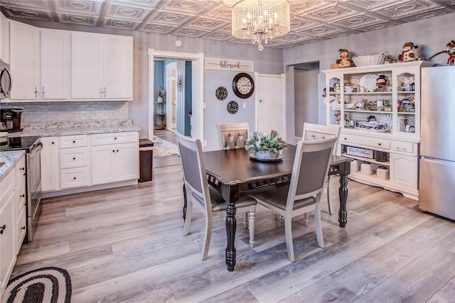 dining room with a notable chandelier and light wood-type flooring