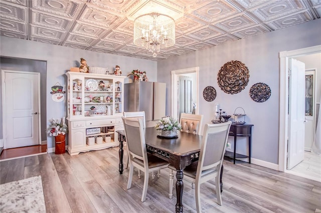 dining space with hardwood / wood-style floors and a notable chandelier