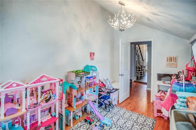 playroom featuring hardwood / wood-style flooring, vaulted ceiling, and a chandelier