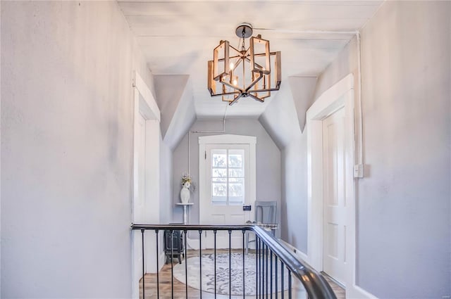 interior space featuring wood-type flooring, lofted ceiling, and an inviting chandelier