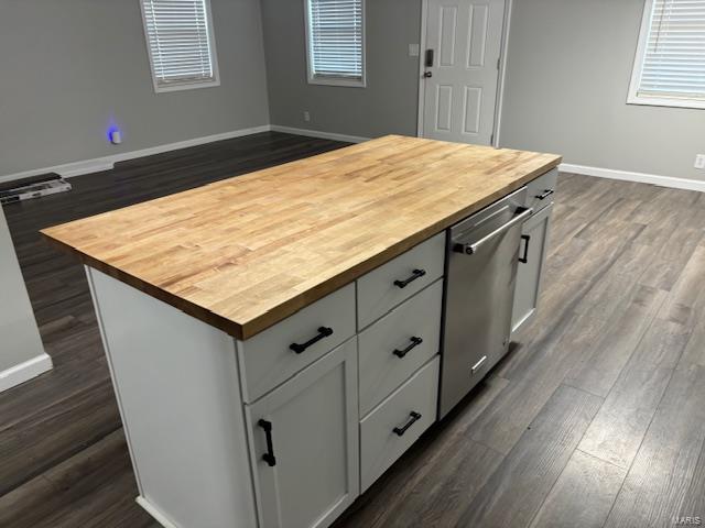 kitchen featuring stainless steel dishwasher, butcher block countertops, white cabinets, and a center island