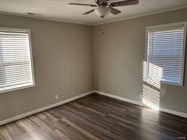 unfurnished room featuring ceiling fan, dark wood-type flooring, and ornamental molding