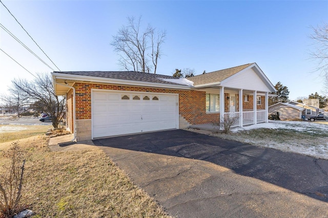 ranch-style home with a porch and a garage