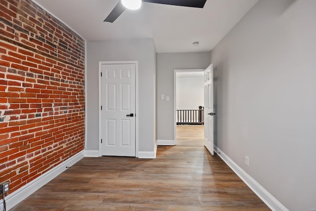 interior space with hardwood / wood-style flooring and brick wall