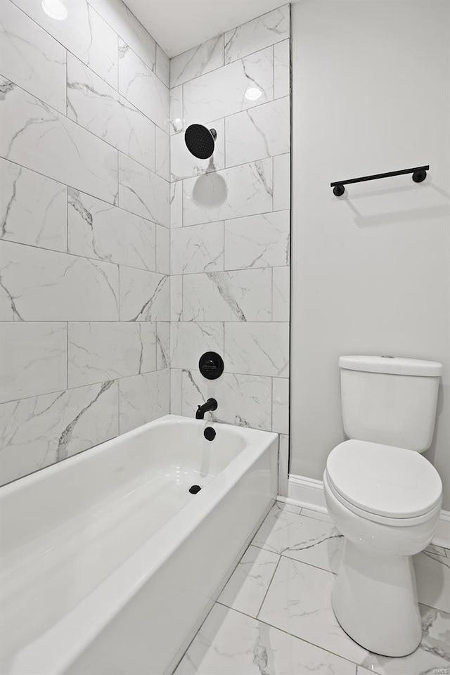 bathroom with toilet and tiled shower / bath