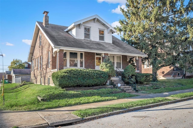 view of front of house with covered porch and a front yard