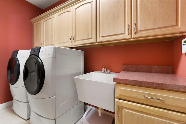 laundry room featuring cabinets, washing machine and dryer, and sink