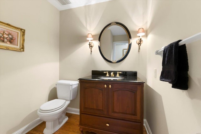 bathroom featuring vanity, hardwood / wood-style floors, and toilet