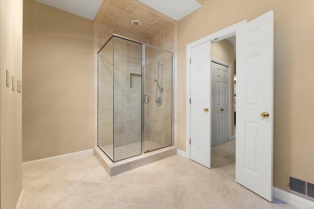 bathroom with an enclosed shower and tile patterned flooring