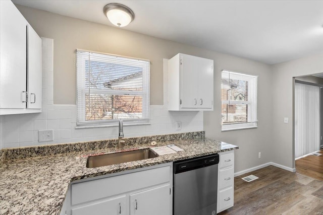 kitchen with white cabinetry, dishwasher, sink, and stone counters