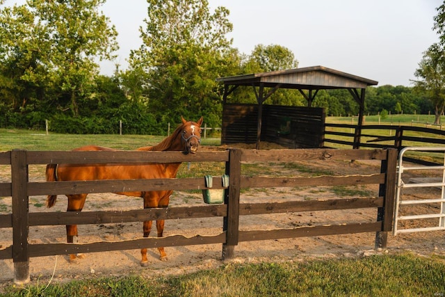 view of gate featuring a rural view and an outdoor structure