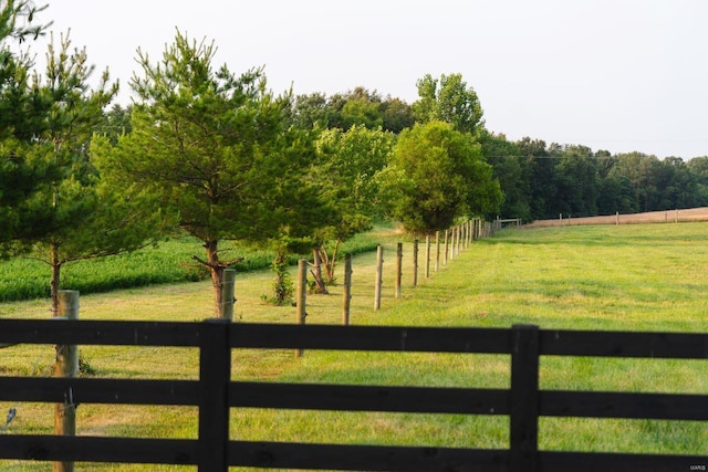 view of gate with a rural view and a lawn