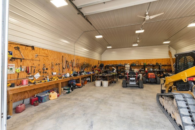 garage with ceiling fan, wood walls, and a workshop area