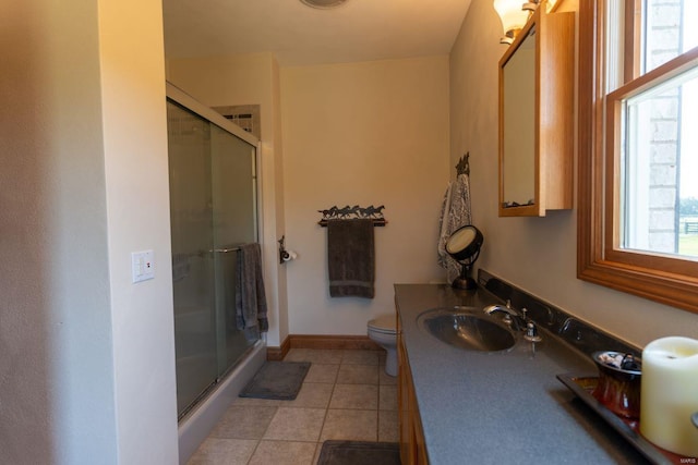 bathroom with a shower with shower door, vanity, tile patterned flooring, and toilet