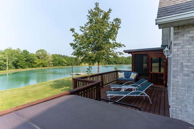 wooden terrace with a sunroom, a water view, and a lawn