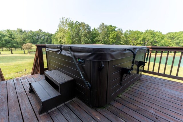 deck featuring a hot tub and a yard