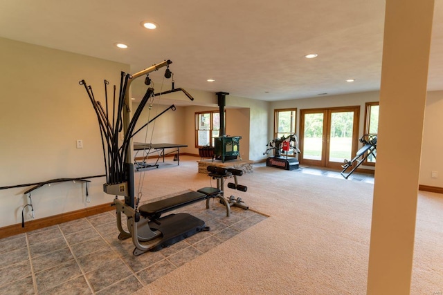 workout room with a wood stove, french doors, and carpet flooring