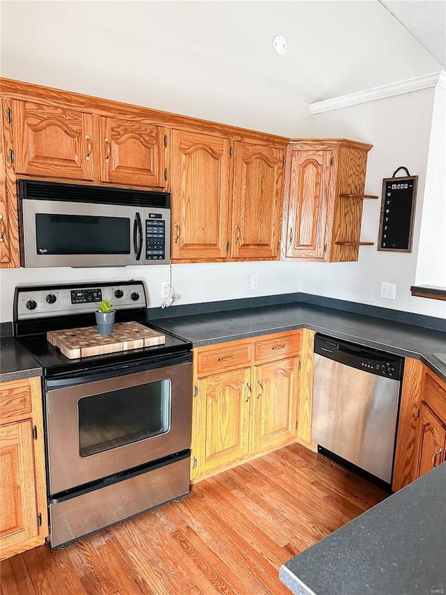 kitchen featuring ornamental molding, light hardwood / wood-style flooring, and appliances with stainless steel finishes