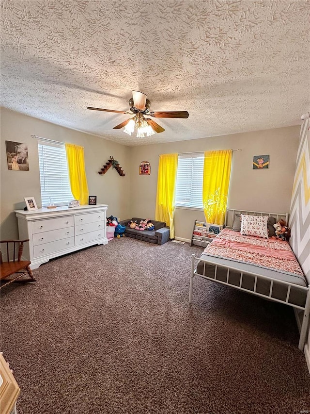 bedroom with carpet, multiple windows, a textured ceiling, and ceiling fan