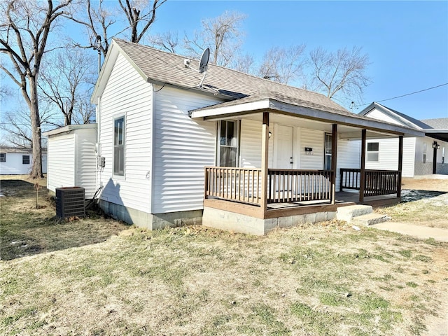 view of front facade with central air condition unit, a porch, and a front yard