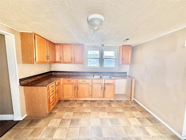 kitchen featuring a textured ceiling and sink